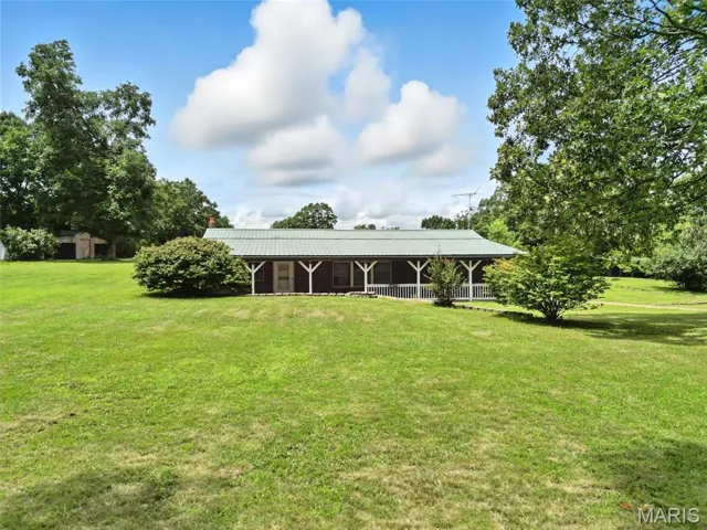 View of green lawn featuring a porch