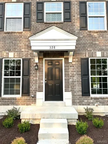 Entrance to property featuring brick siding