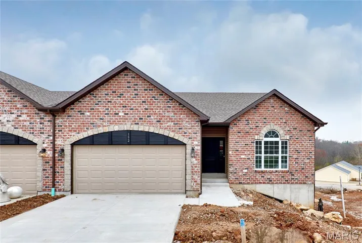 View of front of house with brick siding, a shingled roof, driveway, and a garage