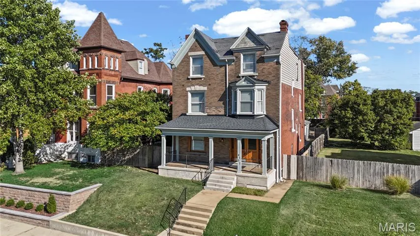 Victorian house with a porch and brick siding
