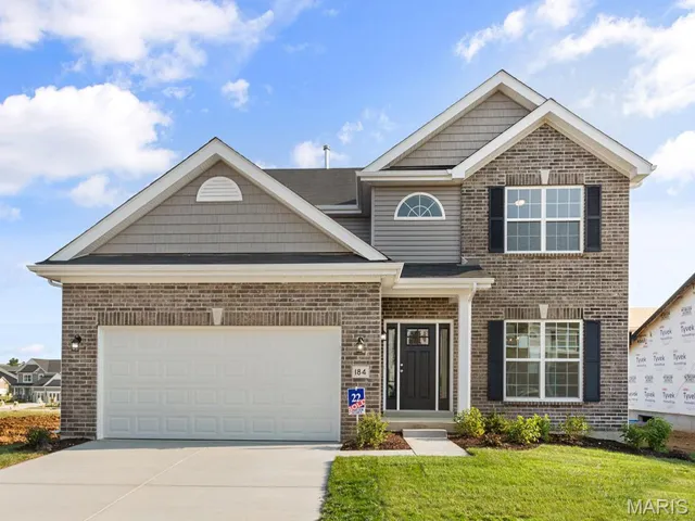 View of front of property featuring a front lawn and a garage