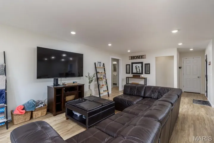 Living room featuring light wood-style flooring and recessed lighting