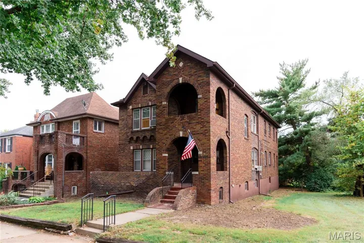 Tudor home featuring a front yard and brick siding