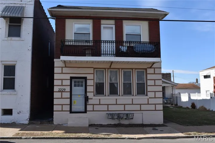 View of front of the building featuring a balcony (2F) and entry steps into 1F