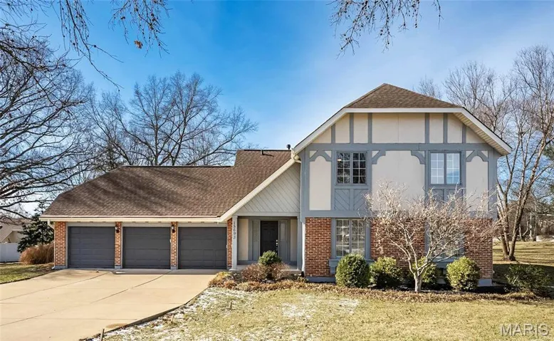 View of front of property with brick siding, roof with shingles, concrete driveway, a garage, and a front lawn