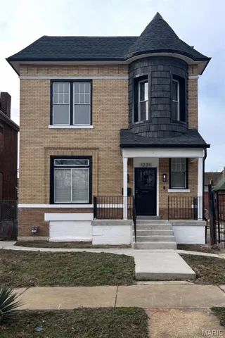 View of front of home featuring a porch, brick siding, and a shingled roof