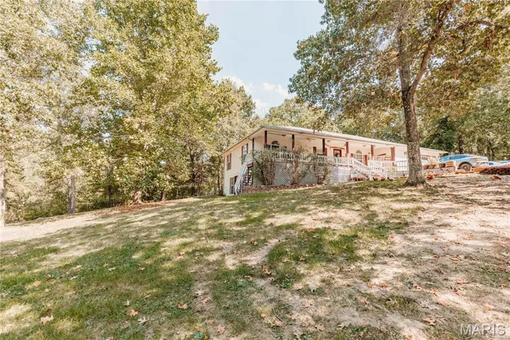 View of property exterior featuring stairs and a lawn