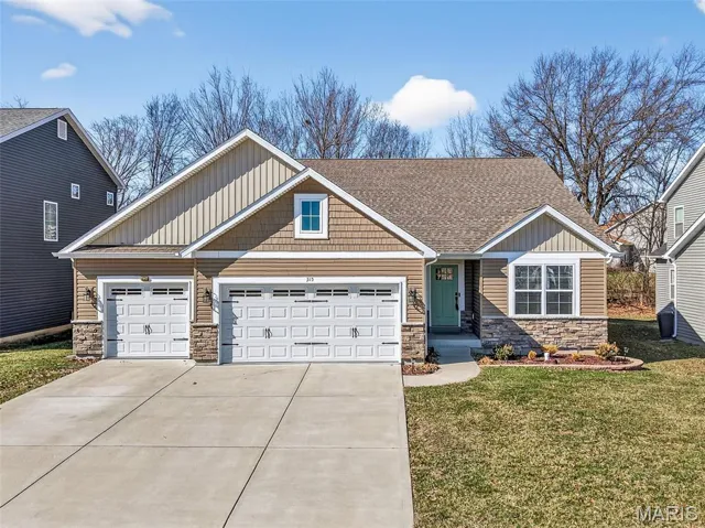 Front Elevation with Stone, Shake Accent Siding, Horizontal and Vertical Vinyl Siding with an Oversized Three Car Garage and Carriage Style Garage Doors