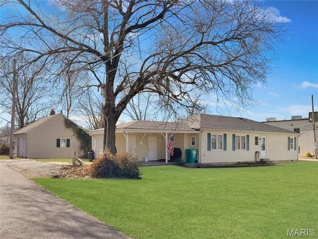Front of home with carport and garage/shop and with electric