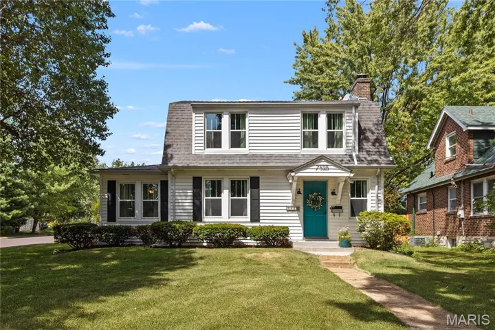 Colonial inspired home featuring a front yard and a chimney