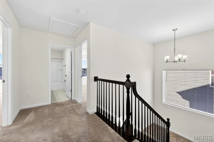 upstairs hallway with split stair case large window for natural light