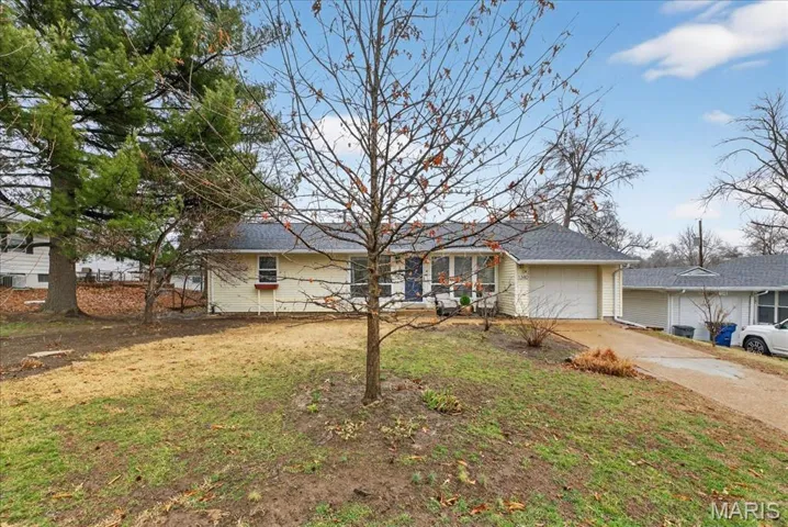 Ranch-style house with driveway, an attached garage, and a front lawn