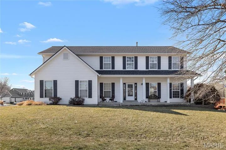 View of front of property with a porch and a front yard
