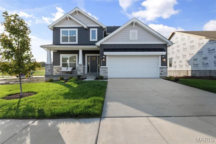Craftsman-style home featuring a garage, a front yard, and a porch