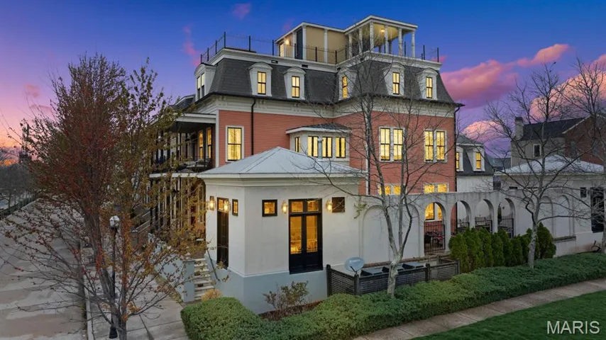View of front of home featuring mansard roof and a balcony