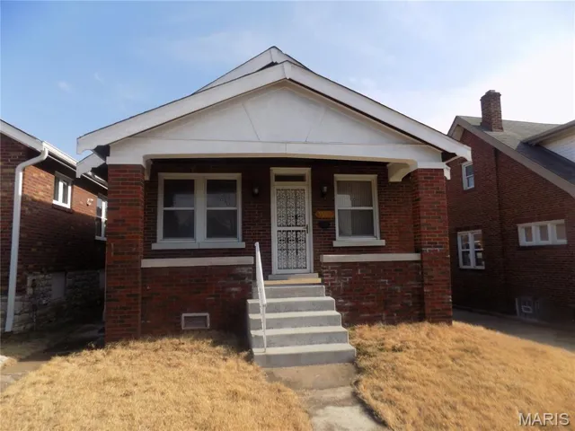 View of front of home with brick siding and covered porch