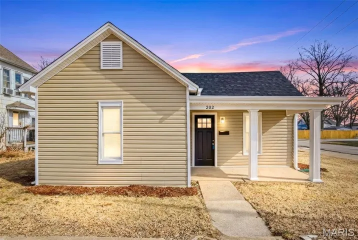 View of front facade featuring covered porch and a shingled roof