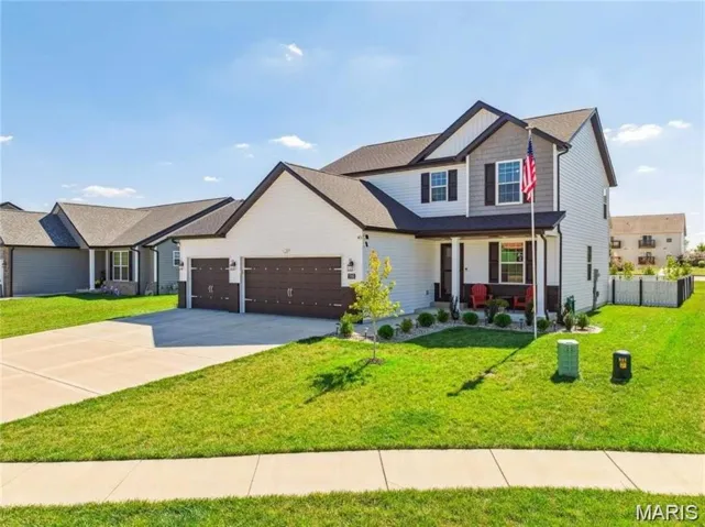 View of front of house featuring a porch, an attached garage, and concrete driveway