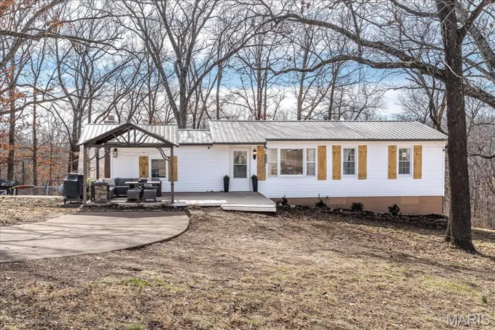 Ranch-style house with outdoor furniture, a gazebo, a patio, and a metal roof