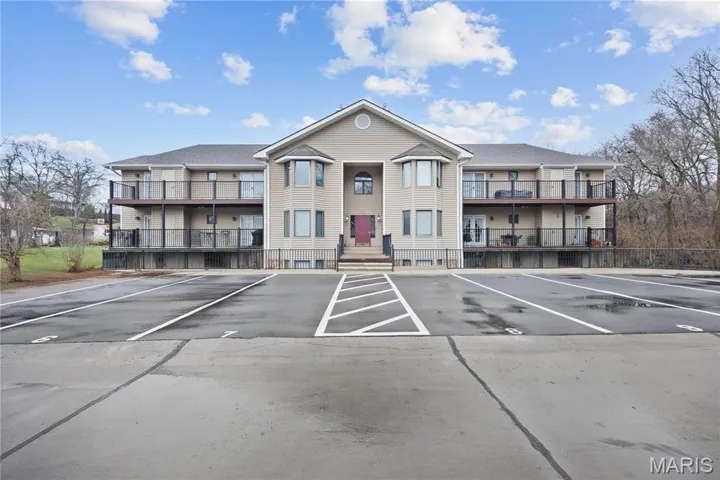 View of building exterior with uncovered parking