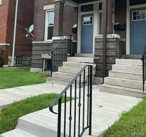 Entrance to property featuring brick siding