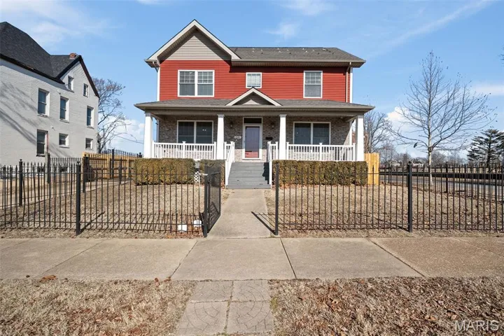 View of the front of the home with a fenced-in front yard and a gate.