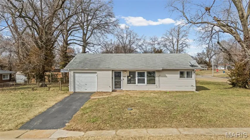 View of front facade with asphalt driveway and a garage