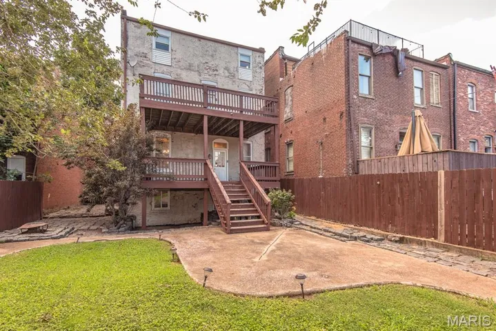 Rear view of house with a deck, stairs, and a patio area