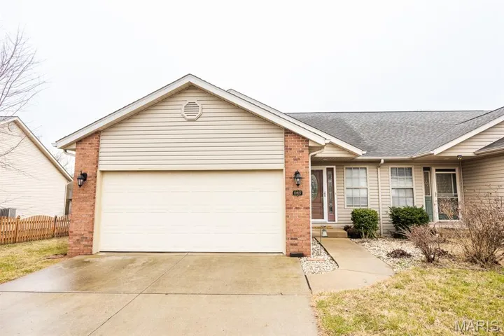 Single story home featuring a garage, brick siding, concrete driveway, and a shingled roof