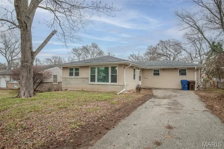 Ranch-style house with brick siding, asphalt driveway, roof with shingles, and a chimney