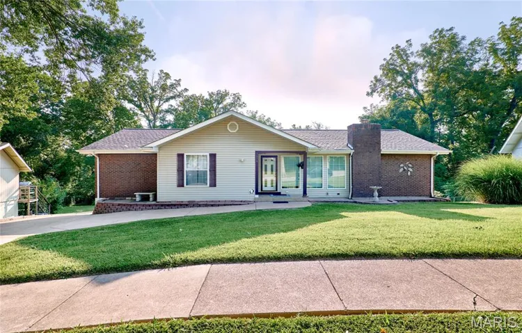 Ranch-style house with a front yard, brick siding, and a shingled roof