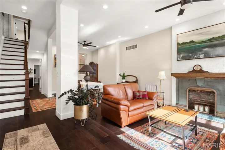 Living area featuring a fireplace with flush hearth, wood finished floors, a ceiling fan, and recessed lighting