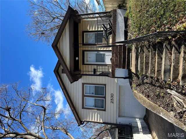 View of front of property featuring covered porch, driveway, and an attached garage