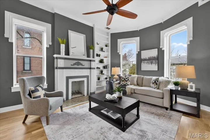 The millwork is exquisite in the Living Room, with crown molding, wood flooring and ceiling fan.