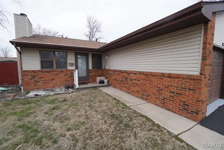 Unit 3170-View of front facade with a front yard, a garage, and brick siding