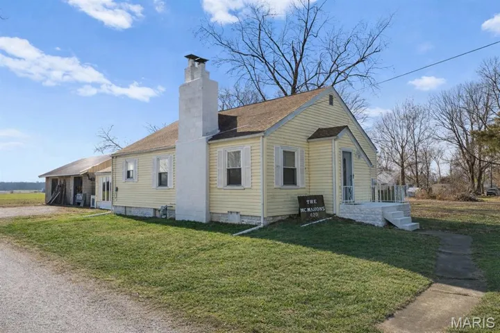 View of home's exterior with a yard, a chimney, and driveway