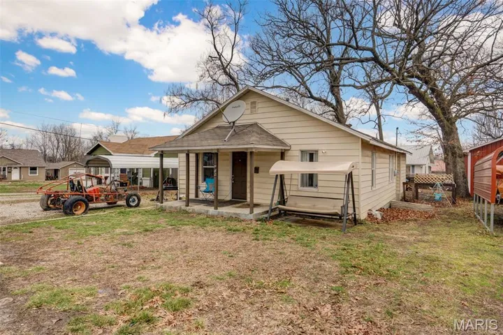 Bungalow with a carport and a front yard