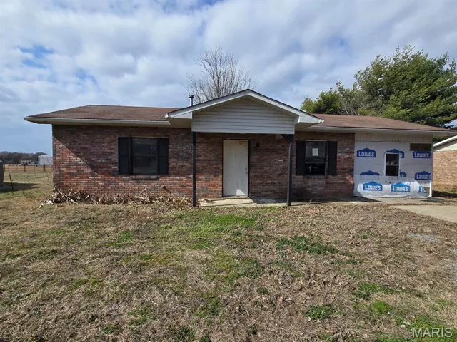 View of front of home with brick siding and a shingled roof