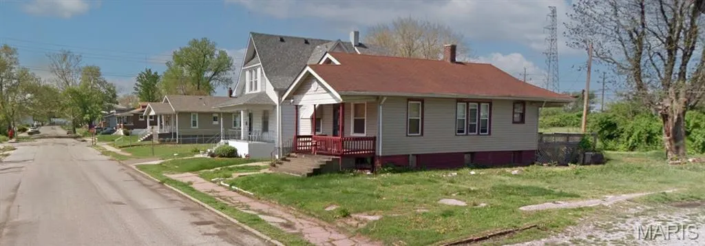 Bungalow featuring covered porch and a front lawn