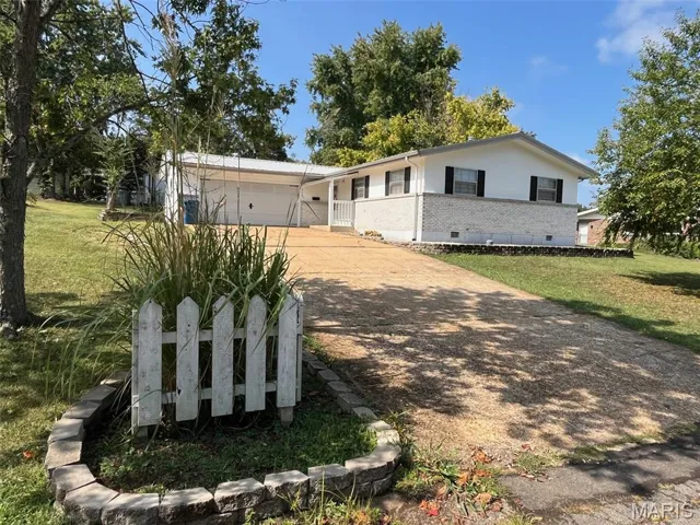 Single story home featuring brick siding, crawl space, a front lawn, driveway, and a garage