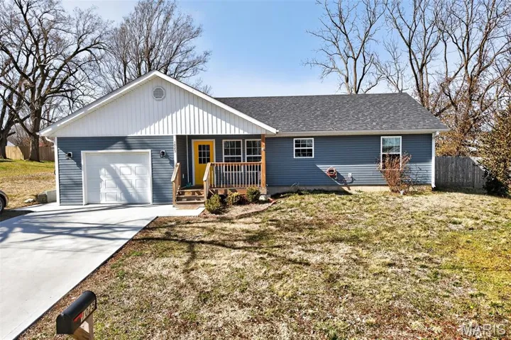 Ranch-style home featuring a garage, concrete driveway, and a shingled roof