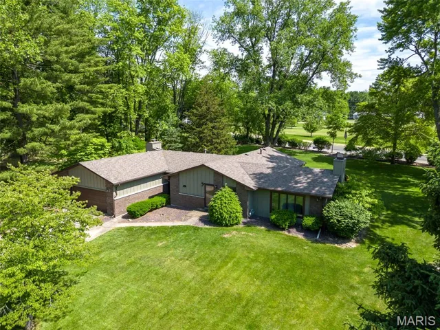 Mid-century home with a front lawn, roof with shingles, and a chimney