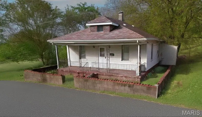 Bungalow-style house featuring a porch, a chimney, a front lawn, and a shingled roof