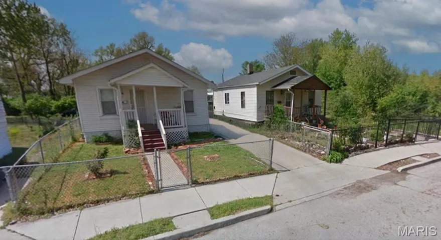 Bungalow-style home featuring a gate, a porch, and a fenced front yard