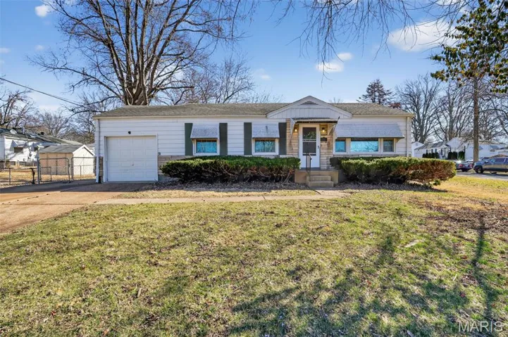 Ranch-style home with concrete driveway, a front lawn, and a garage