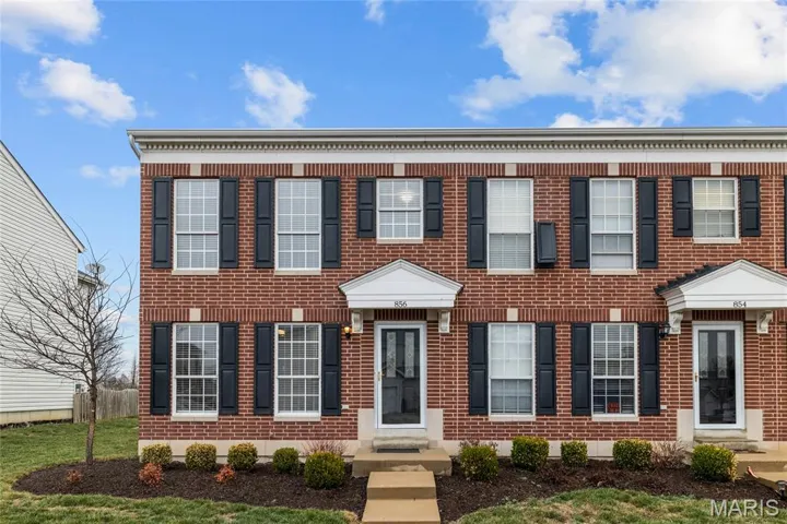 Colonial inspired home featuring brick siding