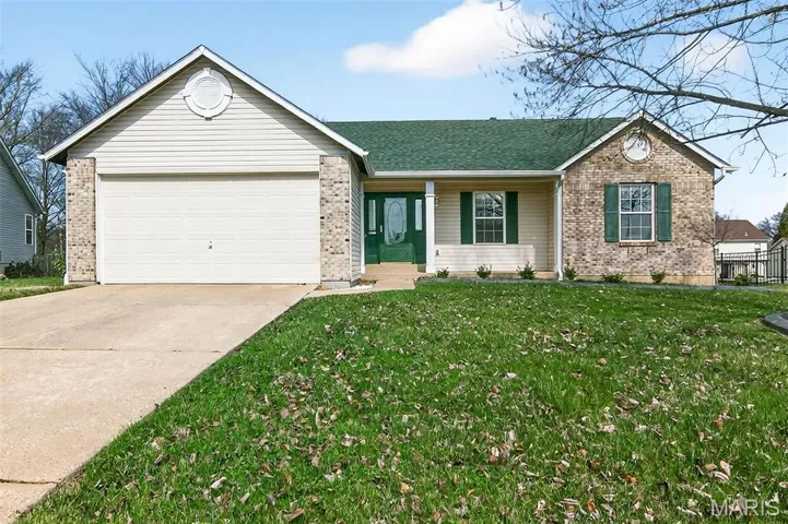 Ranch-style home with brick siding, a garage, concrete driveway, covered porch, and a front lawn
