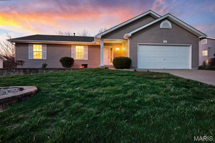 Single story home featuring a front lawn, a garage, and driveway
