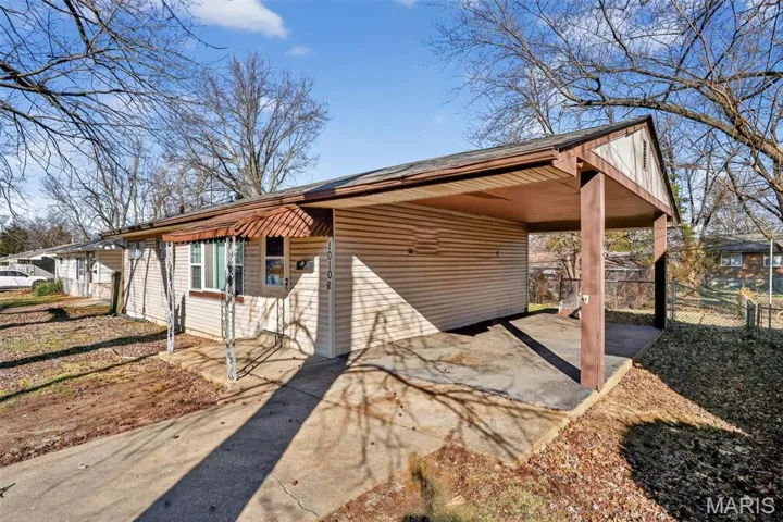 View of front of house with a carport, a patio, and driveway