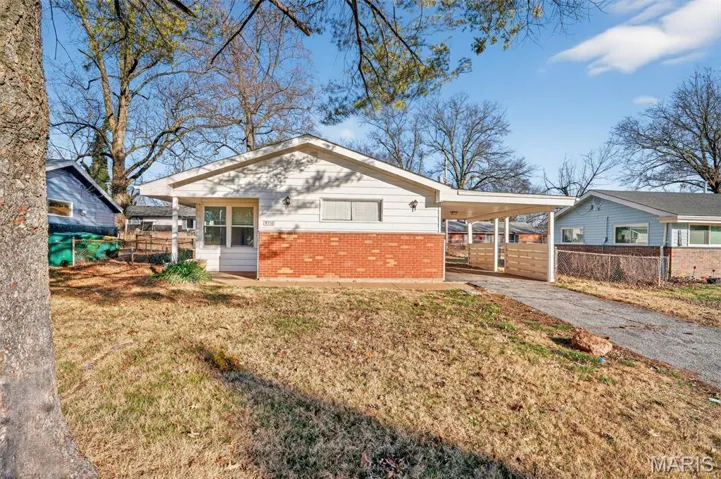 Bungalow-style house with an attached carport, asphalt driveway, and brick siding